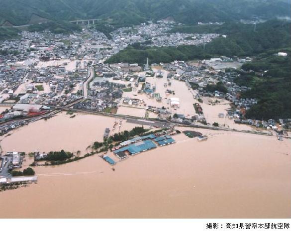 水があふれて、田畑や家が水に浸かっている状況